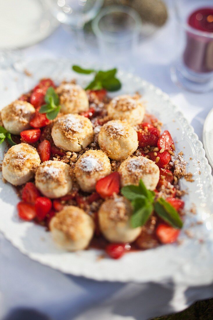 Profiteroles with strawberries on a garden table