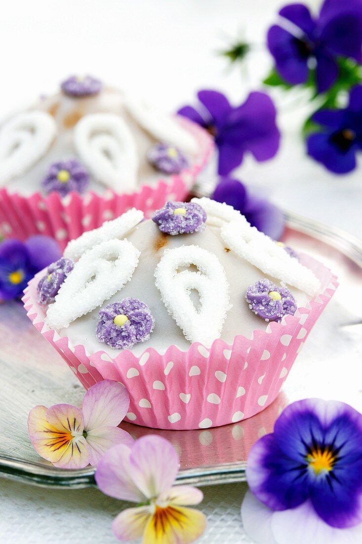 Cupcakes mit Zuckerblüten und Hornveilchen auf Silbertablett