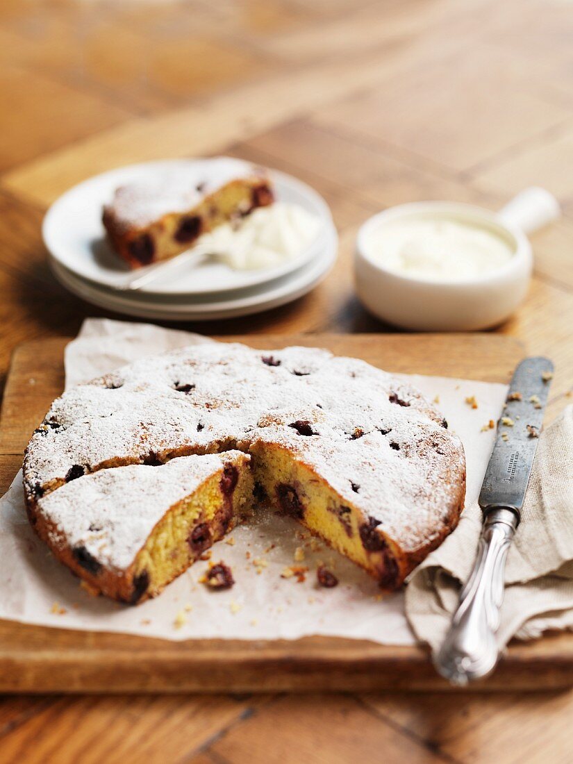 Almond cake with cherries and icing sugar
