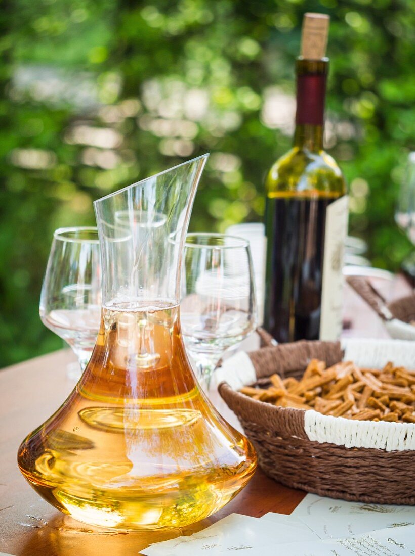 Georgischer Kvevri-Weißwein zur Degustation in Dekantierkaraffe auf Tisch im Freien