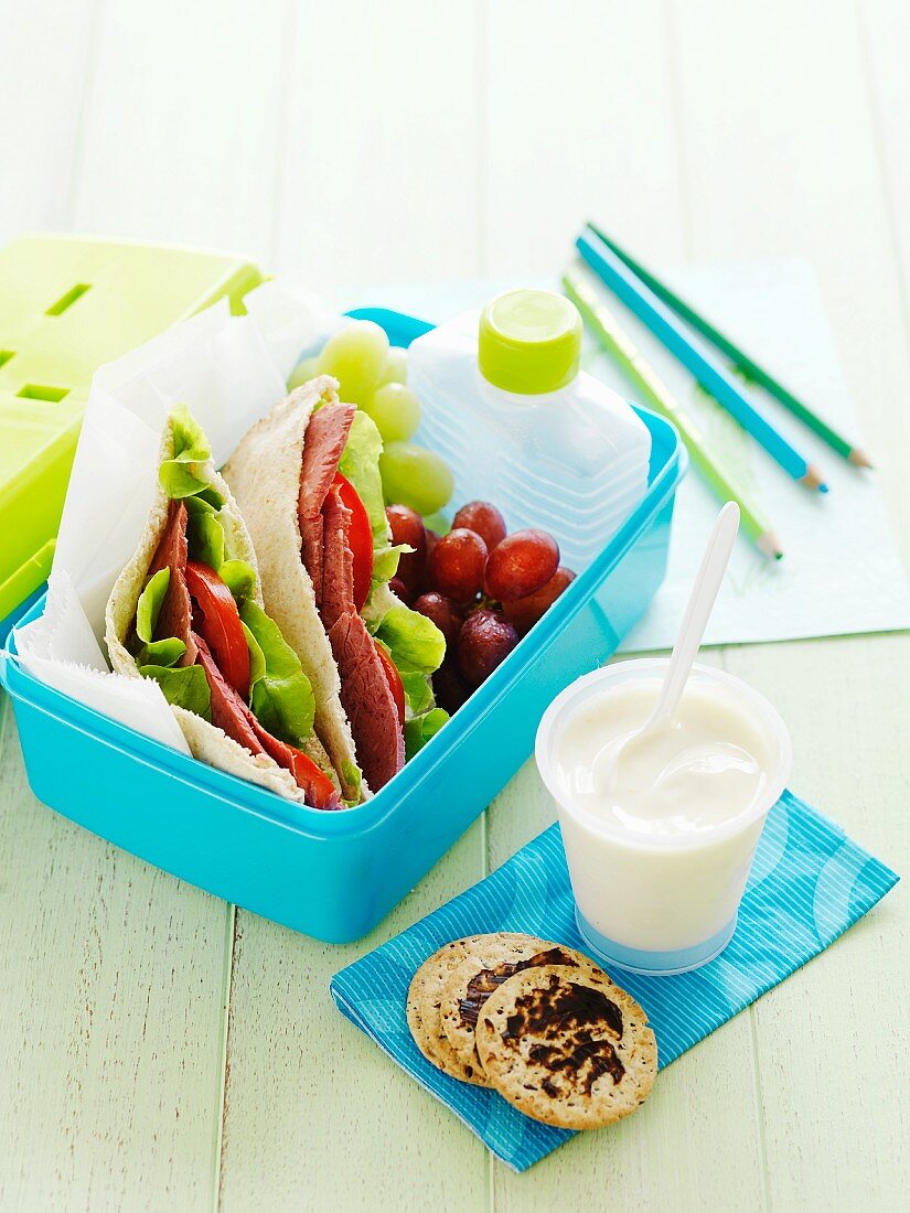 Corned beef pitas, grapes and yoghurt in a lunchbox