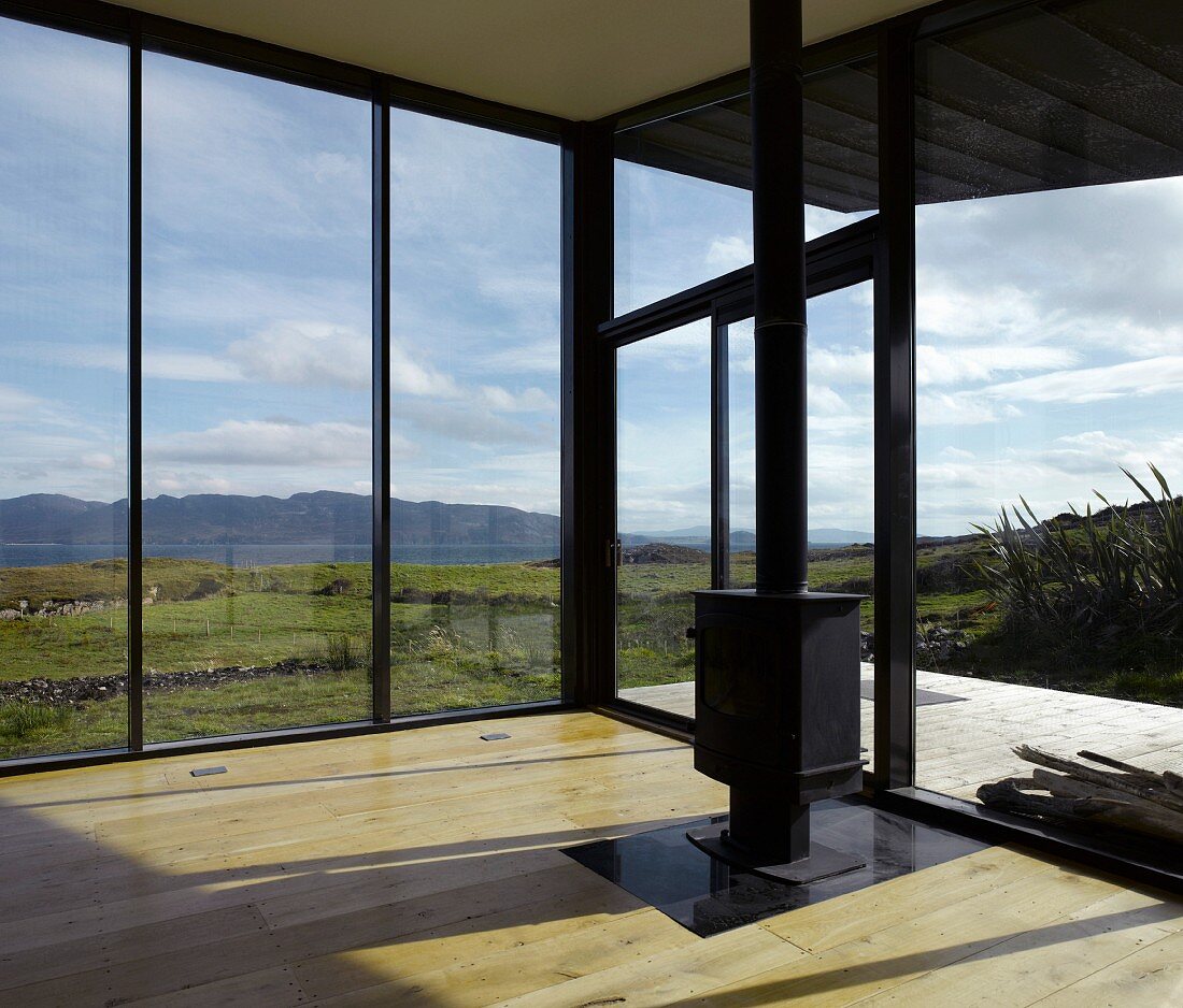 Modern, empty living room with free standing wood burning stove and panoramic view