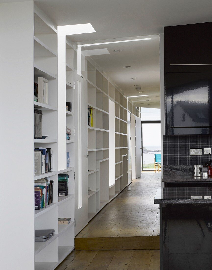 Open hallway with white built-in shelves and patio door at the end wall