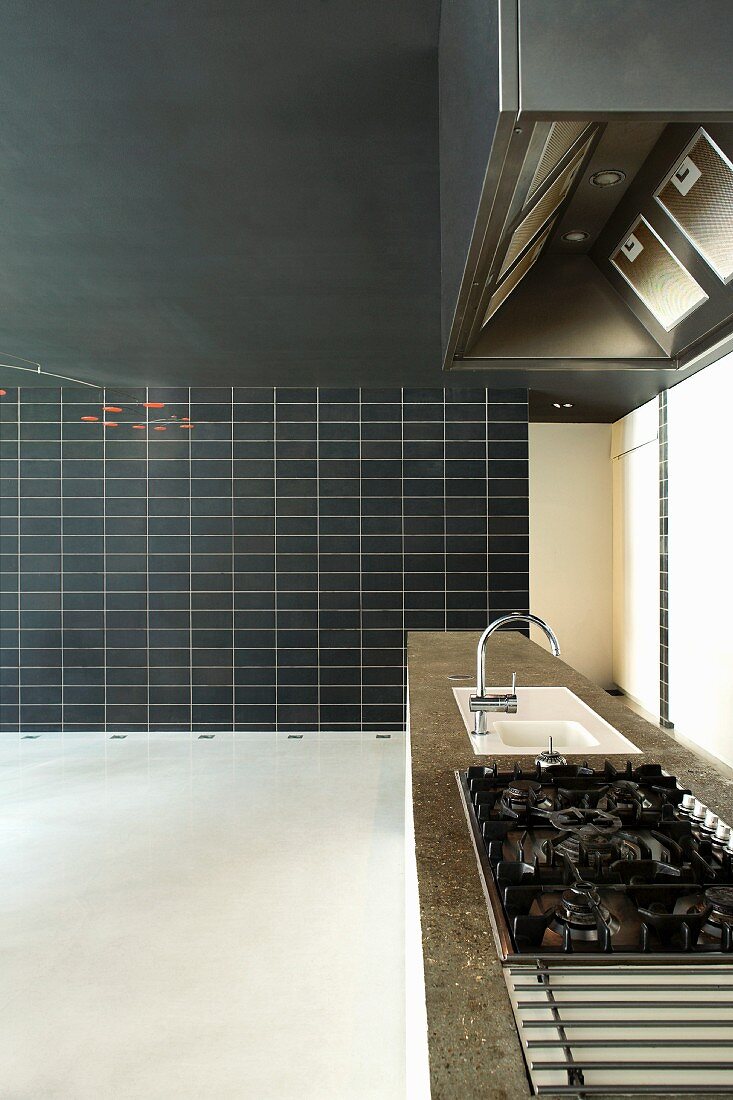 Extra long kitchen unit and floor to ceiling, black, partially tiled wall