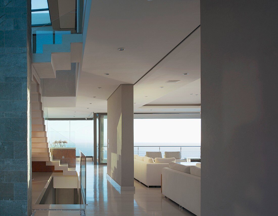 Open plan house with room dividers separating the staircase from the living room with a view of the sectional sofa