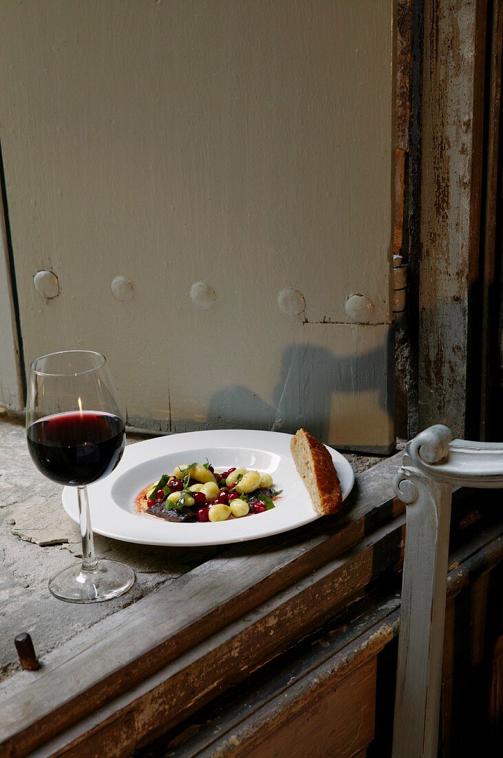 Beef with potatoes, basil and lingon berries and a glass of red wine