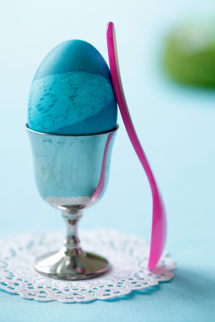 A blue Easter egg in an egg cup