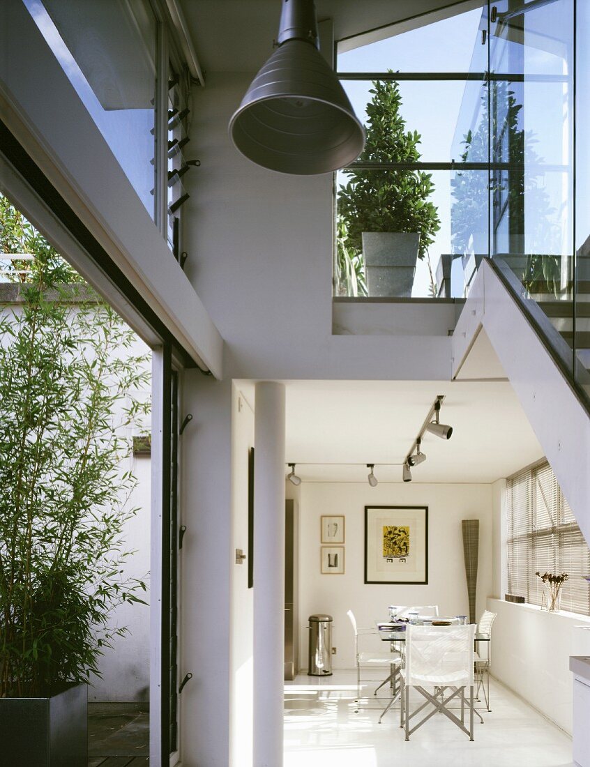 Contemporary home with dining area in an open living room with a view into a glassed-in stairwell