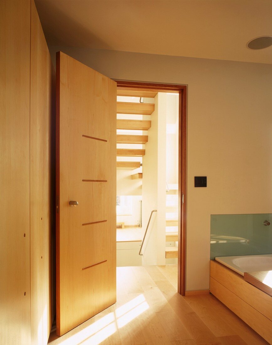 Designer bath with bathtub next to an open wooden door in Japanese style