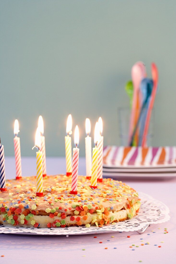 A birthday cake with candles and sugar sprinkles