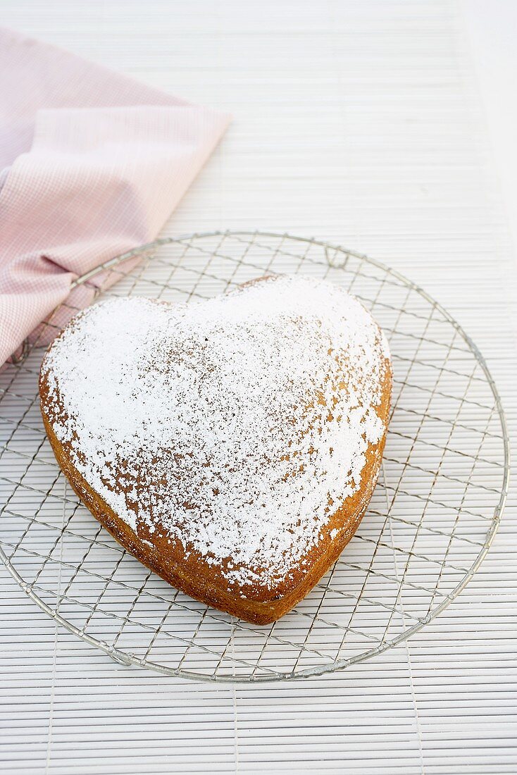 A heart shaped sponge cake dusted with icing sugar