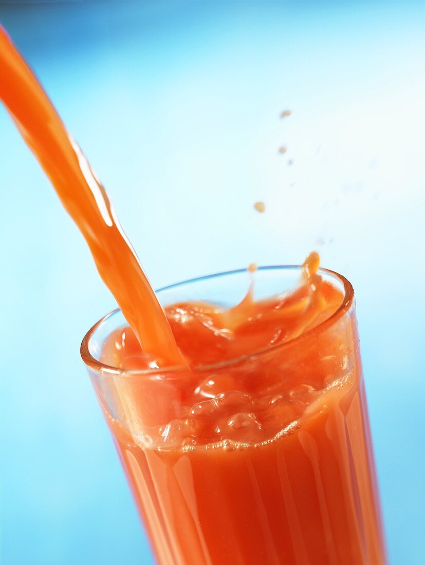 Fruit juice being poured into a glass