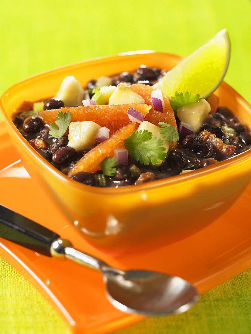 Black bean soup with orange fillets and lime wedges