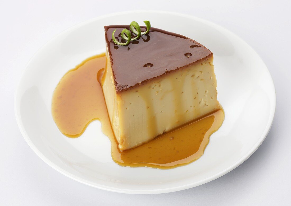 A slice of crème caramel with a garnish of lime