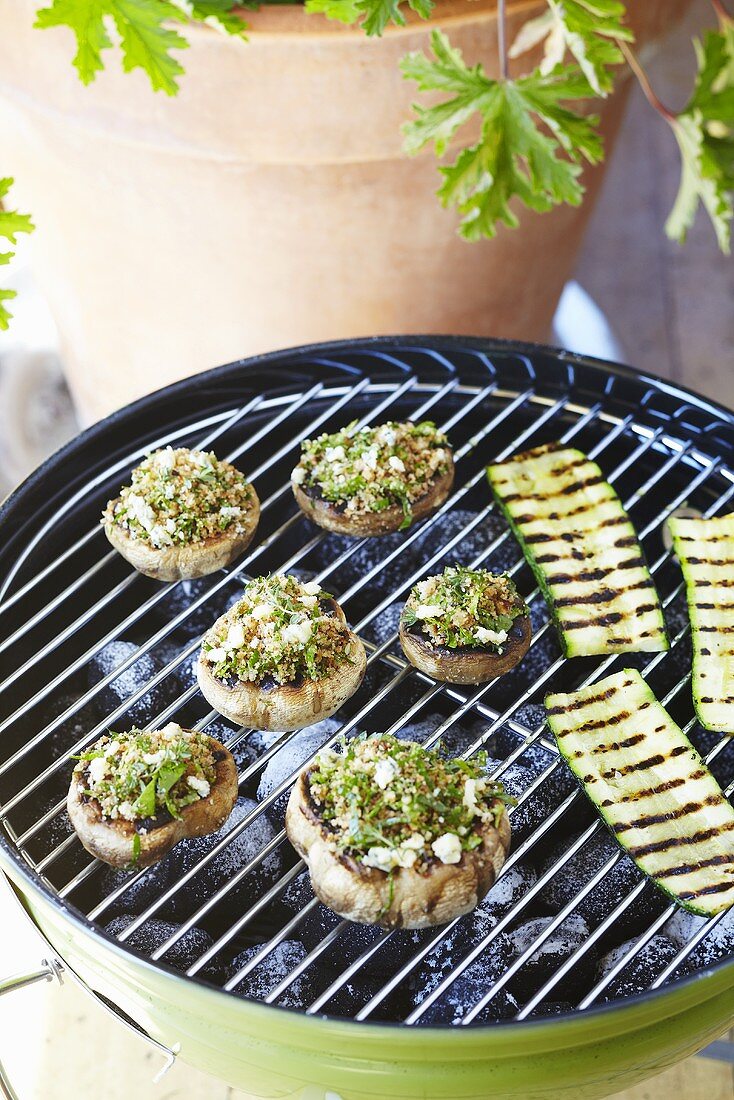 Stuffed mushrooms and courgette slices on a barbecue