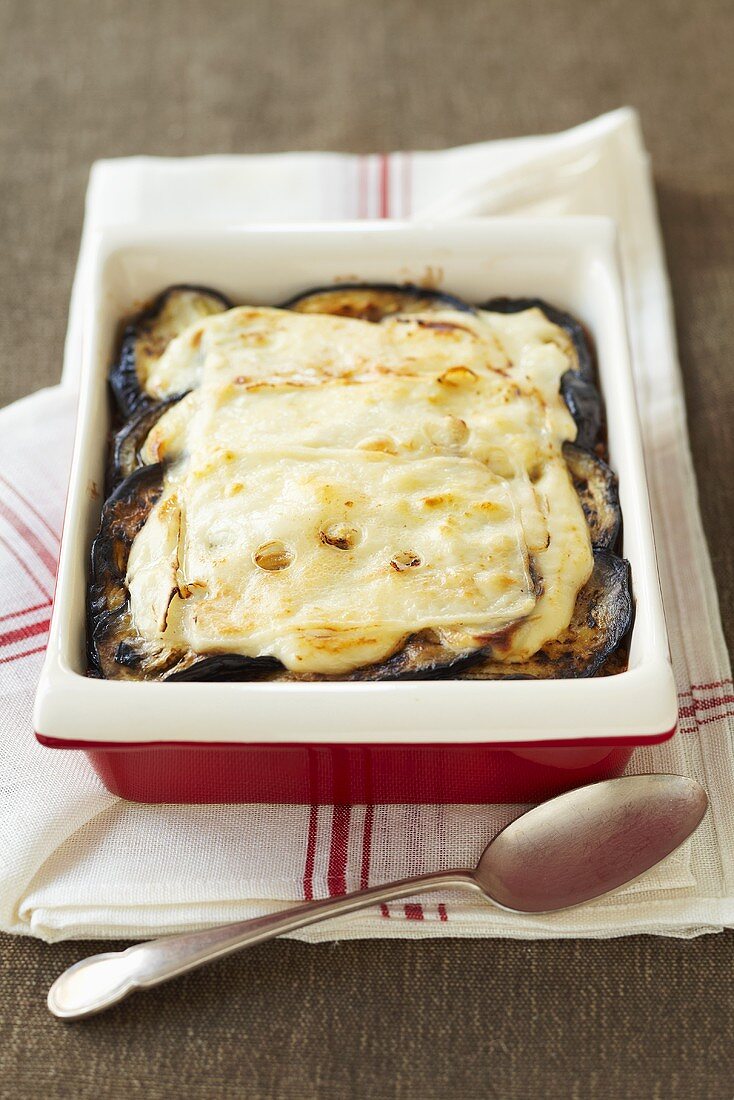 An aubergine bake in a baking dish with cheese on top