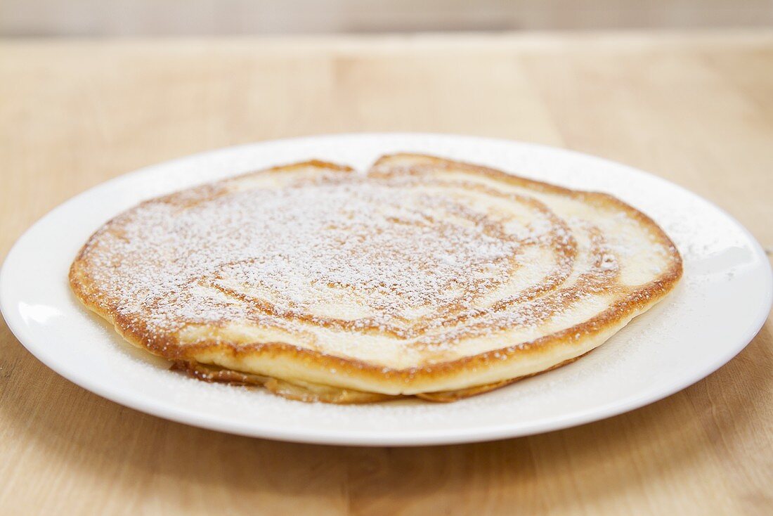 A pancake dusted with icing sugar