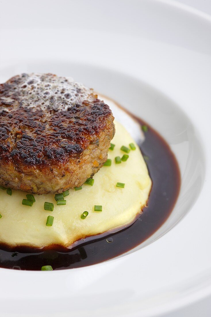 A veal burger with mashed potatoes and gravy