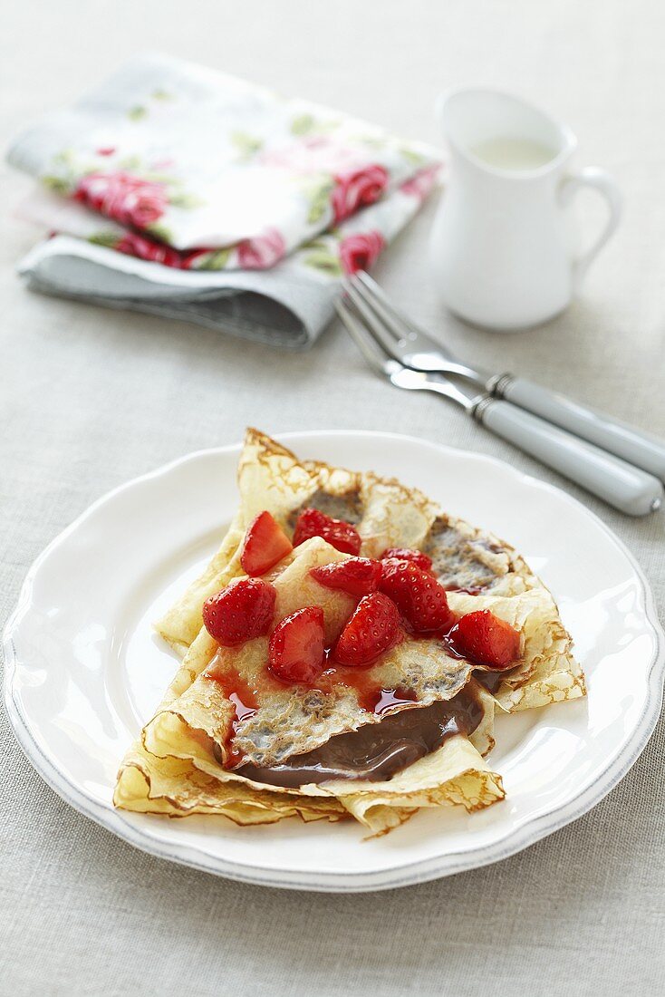 Pancakes with chocolate sauce and strawberries