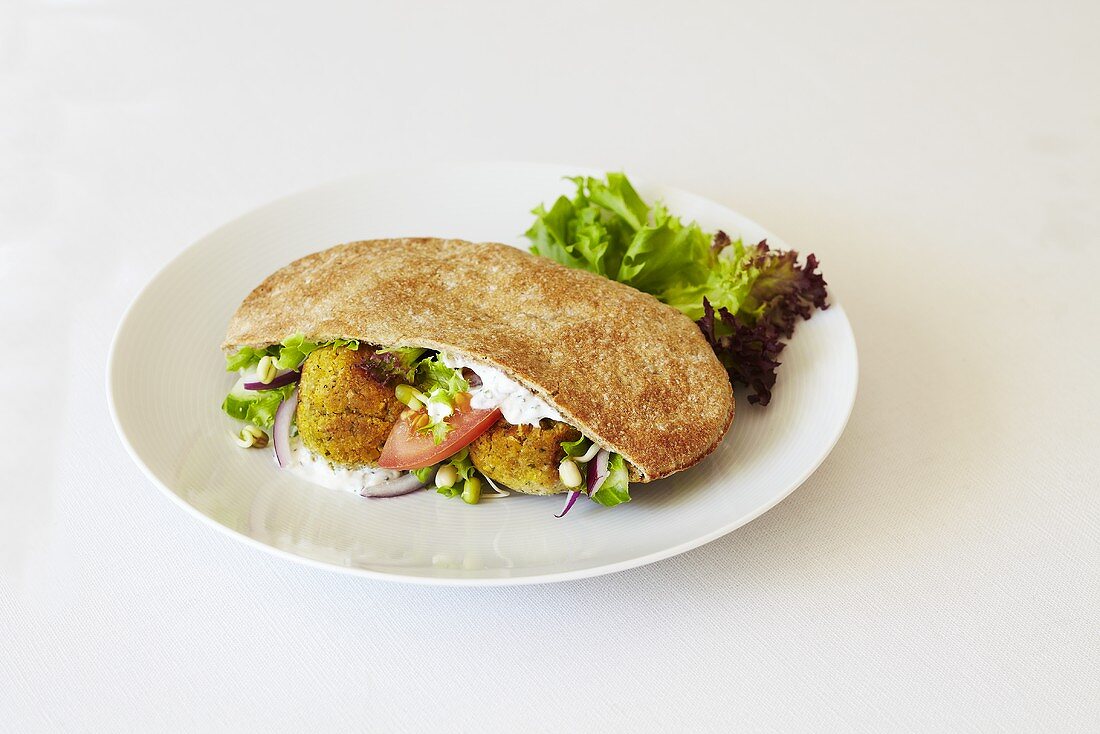 Falafel in a pitta bread against a white background