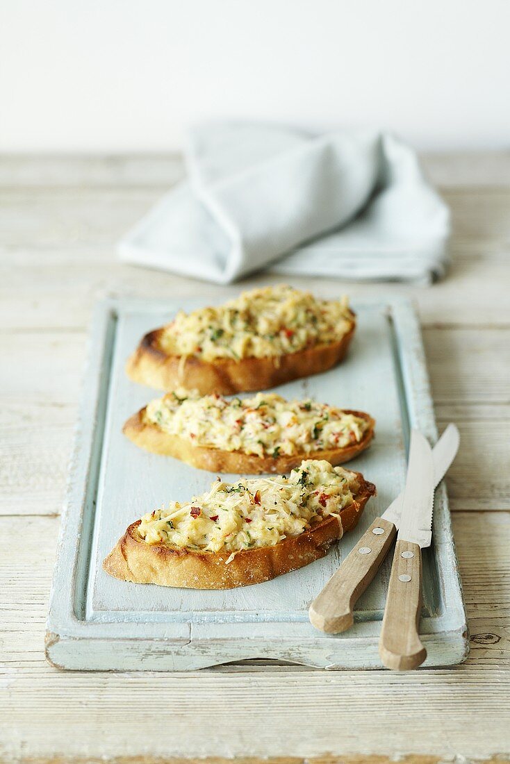 Geröstete Brotscheiben mit Krebsfleisch auf Holzbrett