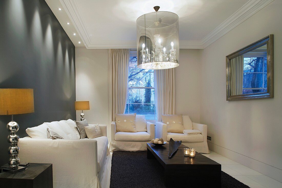 Eleganter Wohnraum mit Polstergarnitur und Designer Hängelampe mit integriertem Kerzenleuchter