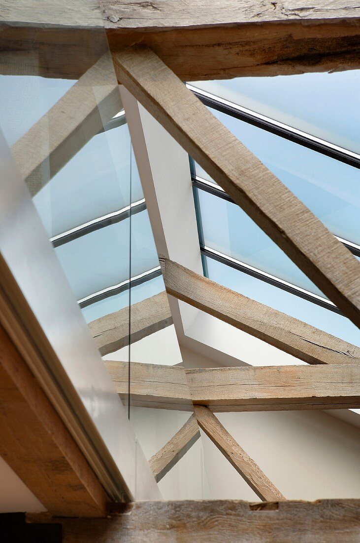 View of a modern skylight above old, rustic wooden construction