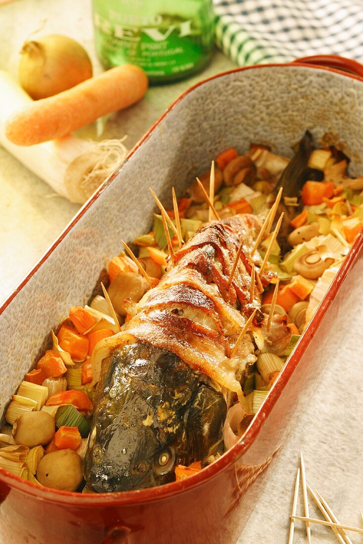 Stuffed carp wrapped in bacon in a butter and port sauce
