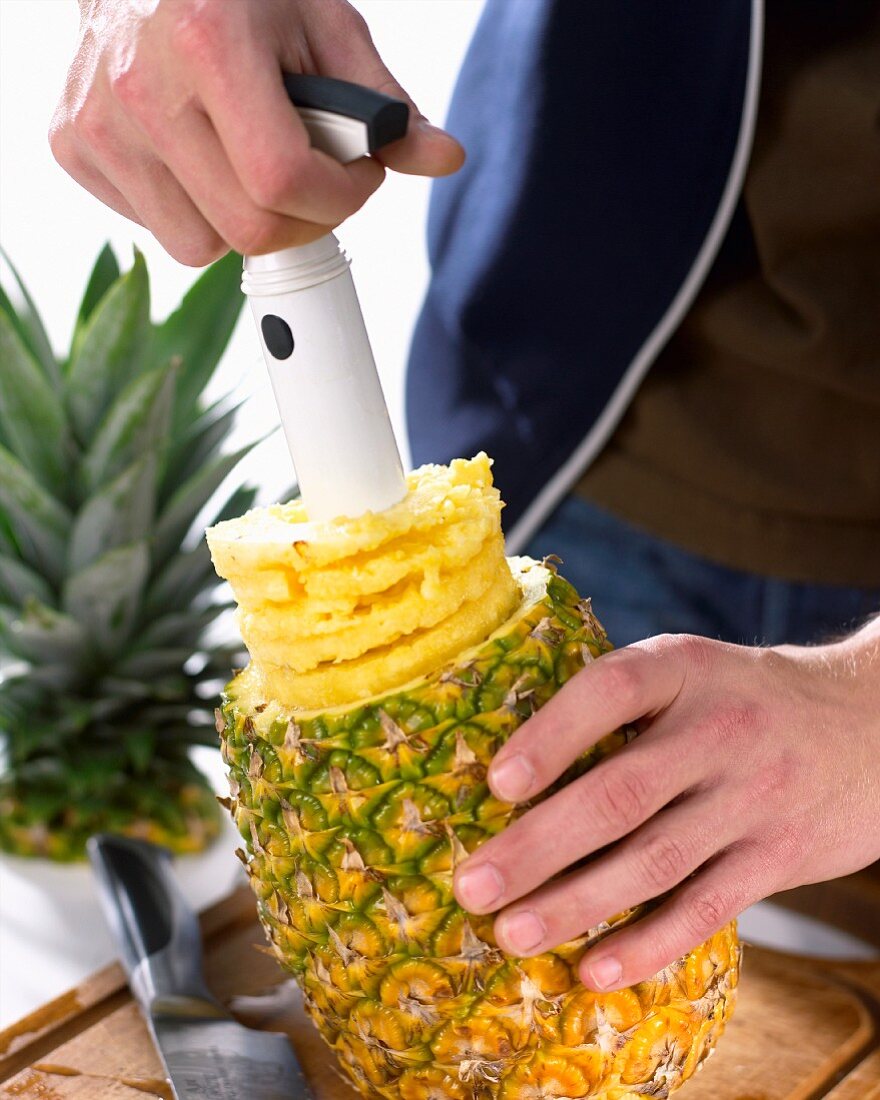 Pineapple slices being made with a pineapple cutter