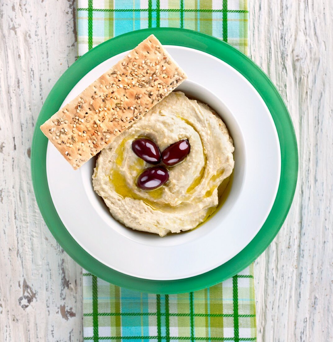 Hummus mit Olivenöl, Olivendeko und Sesambrot