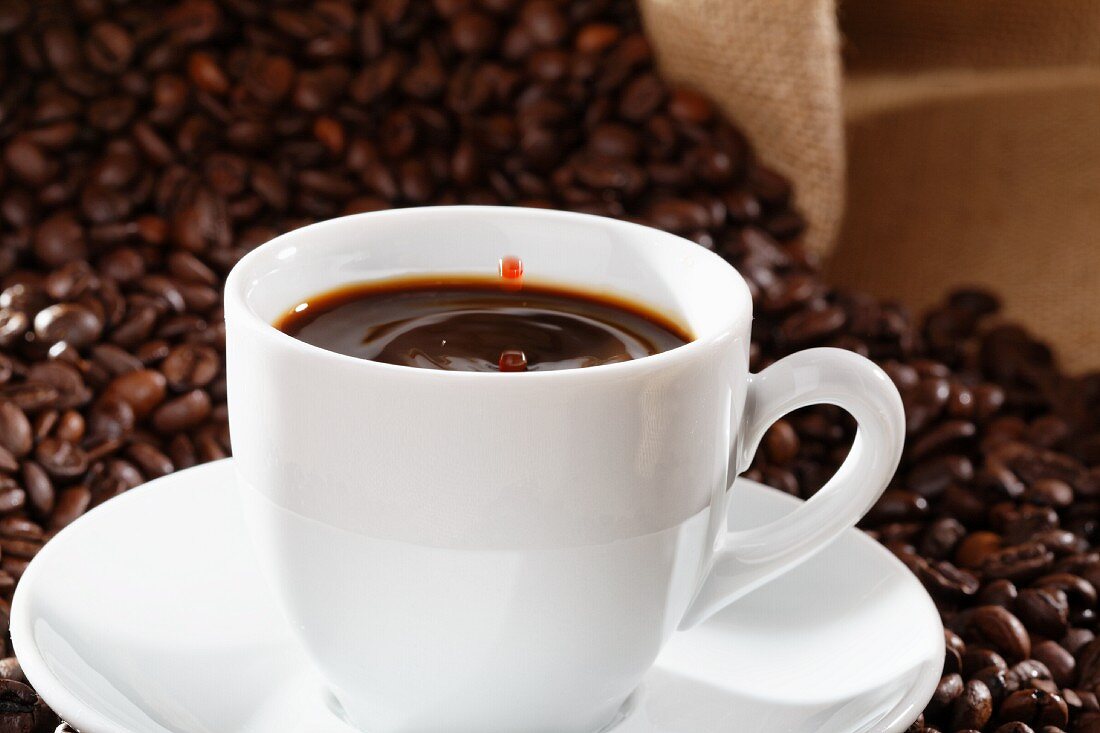 Kaffeetropfen fällt in eine Tasse Kaffee