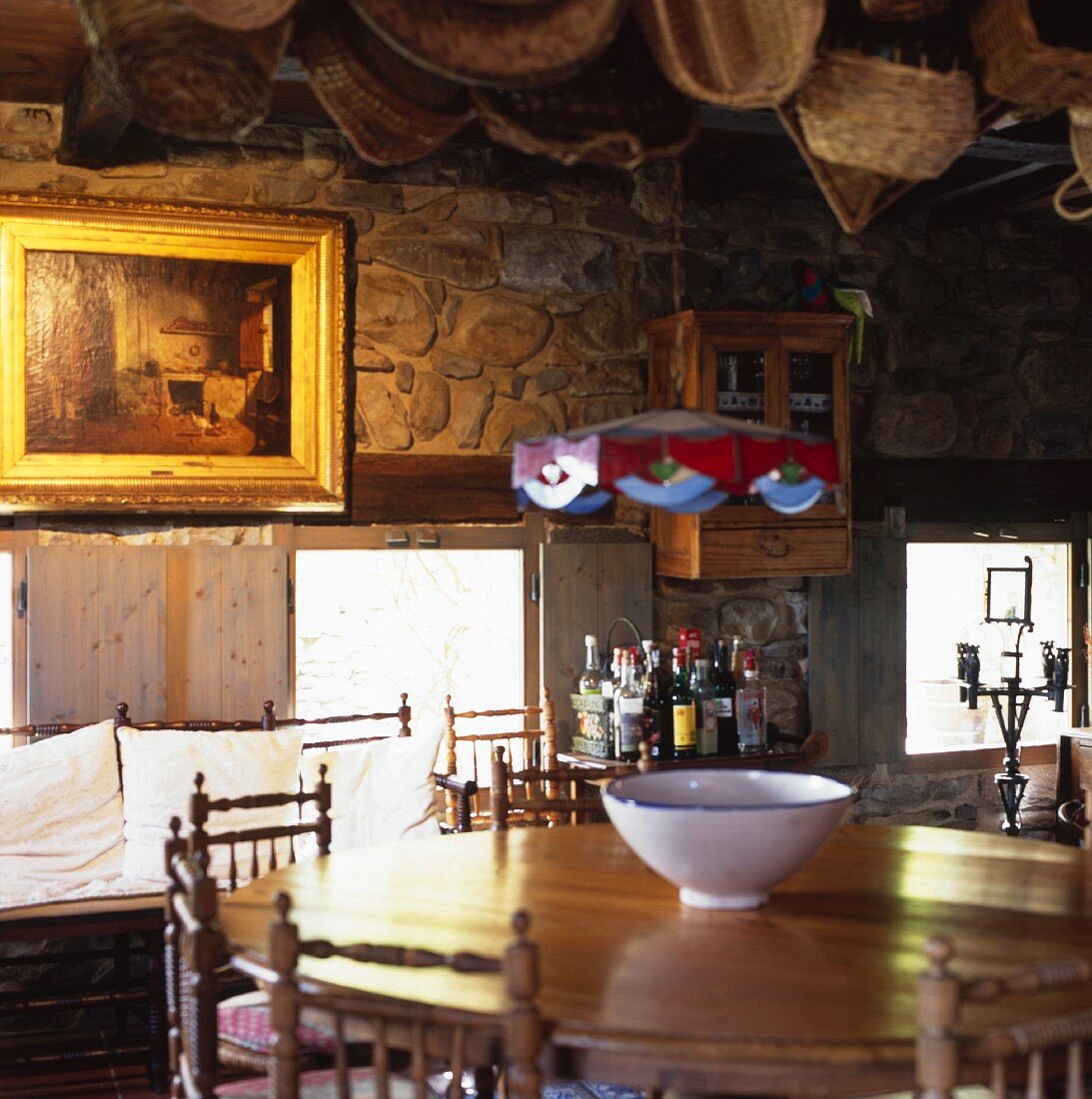 Round, wooden dining table and chairs with carved back rests in a Spanish kitchen in a country home