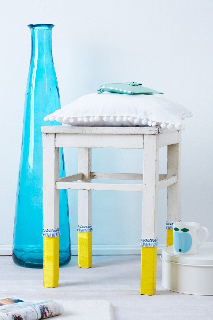 A stool with stockings next to a blue floor vase