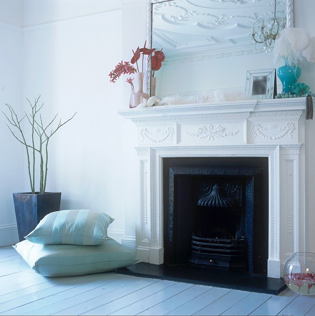 Floor cushions next to a fireplace decorated with stucco