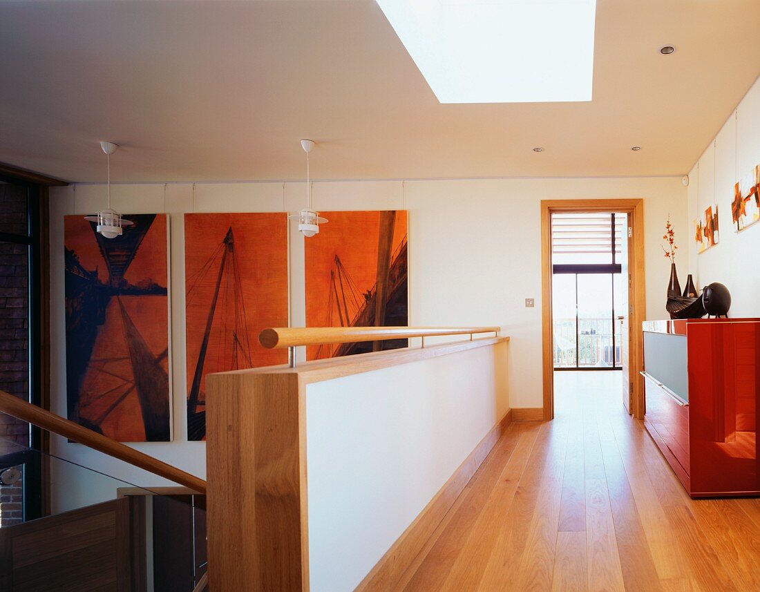 A modern stairwell and a corridor with parquet flooring leading to an open door