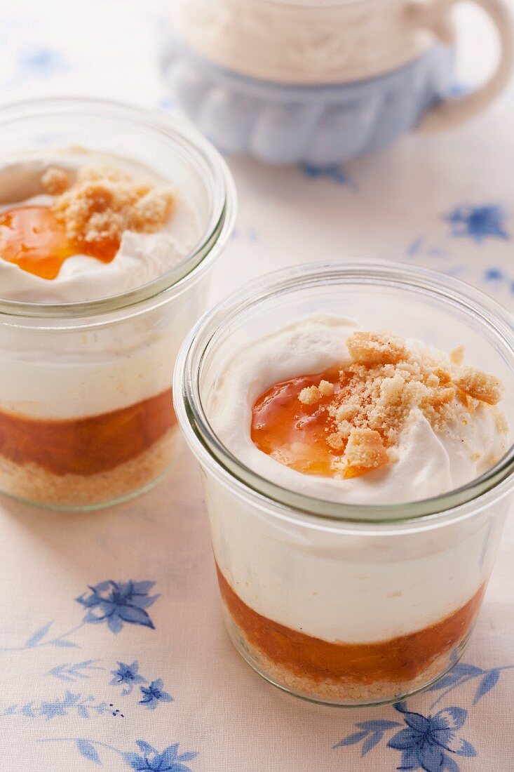 Layered desserts with apricot compote, creamy yoghurt and biscuit crumbs