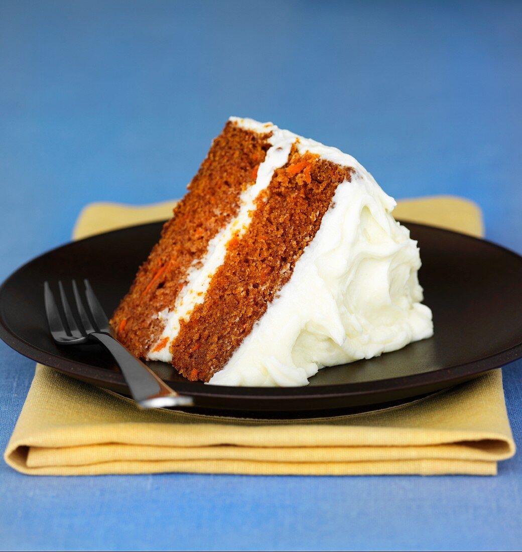 A slice of carrot cake topped with cream