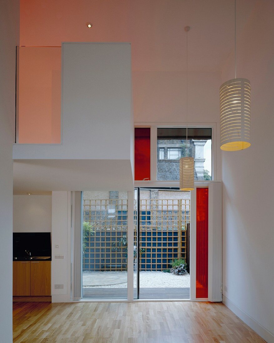 Entrance with lantern-like pendant lamps, strip parquet and wide glass door with red elements