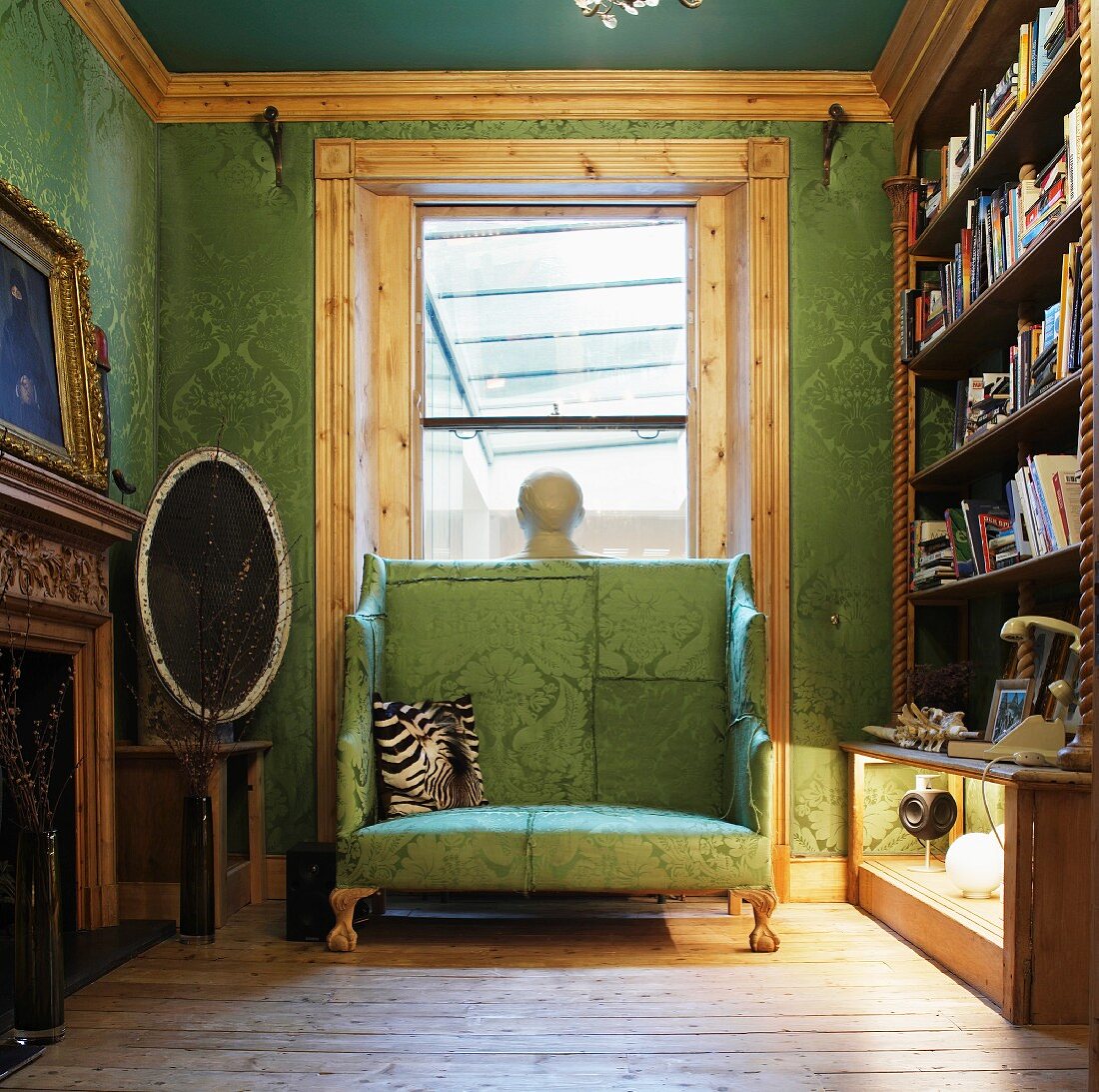 Upholstered high-backed bench in front of window in library - cover fabric and wallpaper with same colour and patter