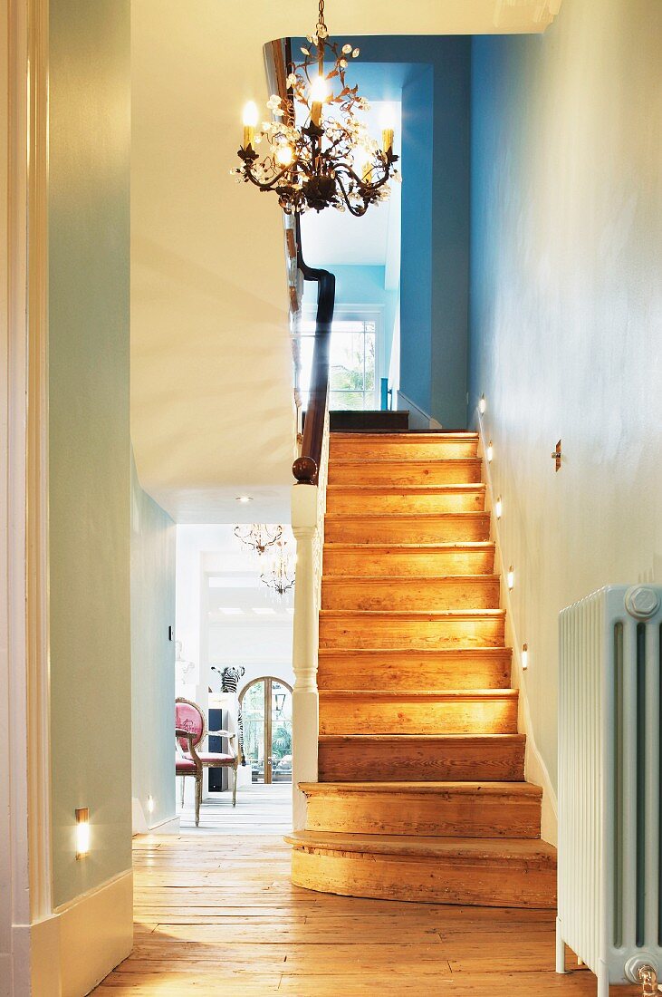 Recessed spotlights on wooden stairs in traditional stairwell