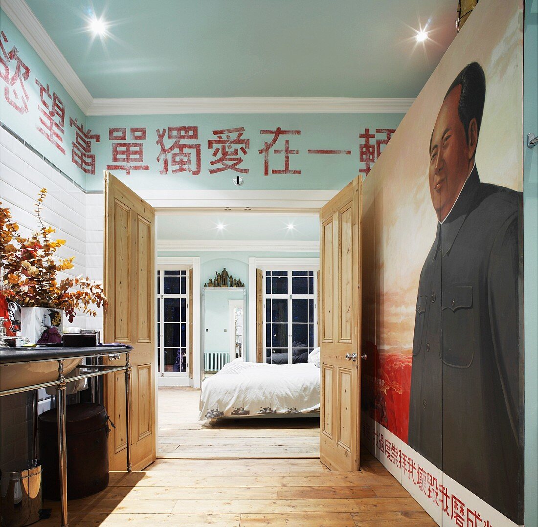 Ensuite bathroom with mural and Chinese characters on wall above open bedroom wall
