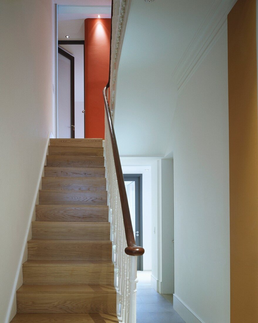 Modern entrance area with wooden stairs and wrought iron balustrade