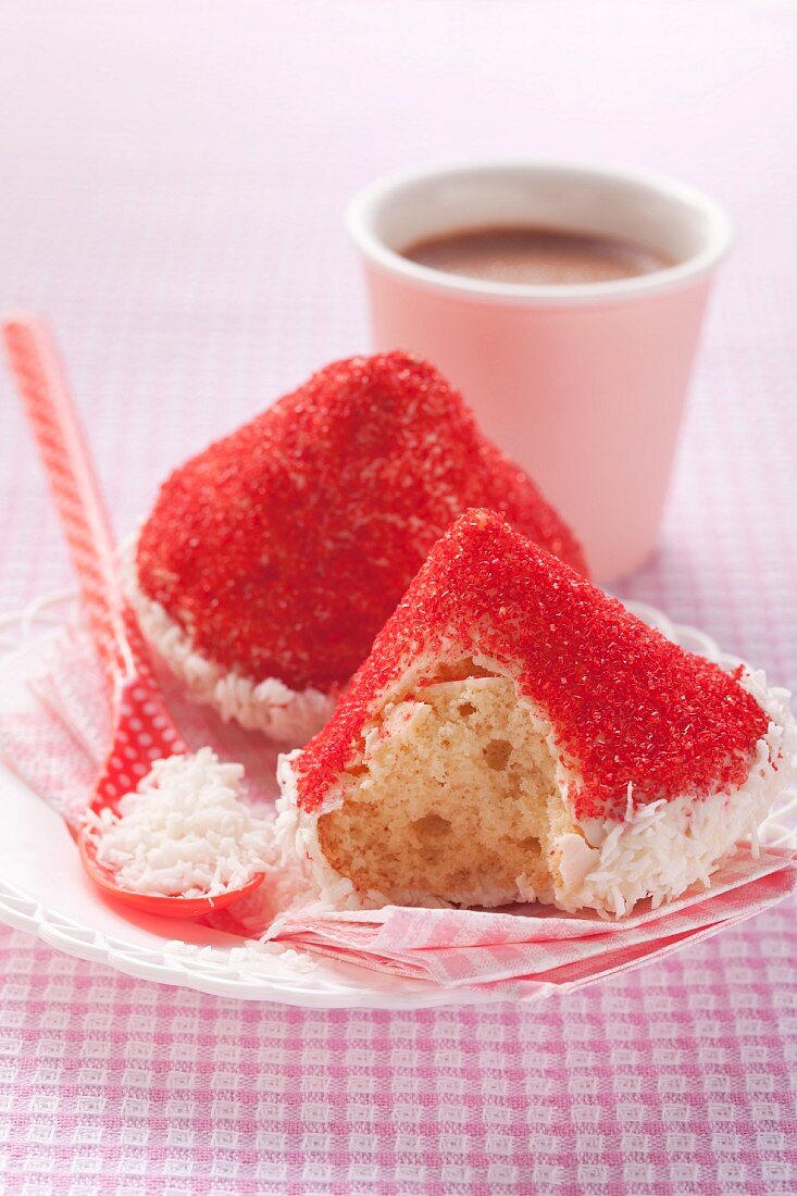 Süsses Gebäck mit rotem Hütchen aus Kokosraspeln und Zuckerstreuseln