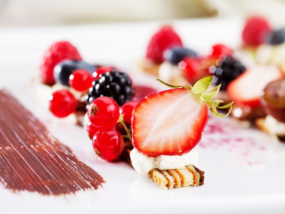 A desert made with fresh berries and slices of layer cake