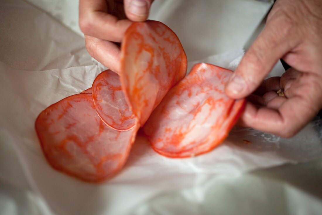 Hands Placing Capicola on Butcher's Paper at an Italian Market in Baltimore Maryland