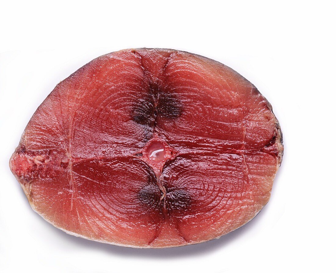 A raw tuna steak on a white surface