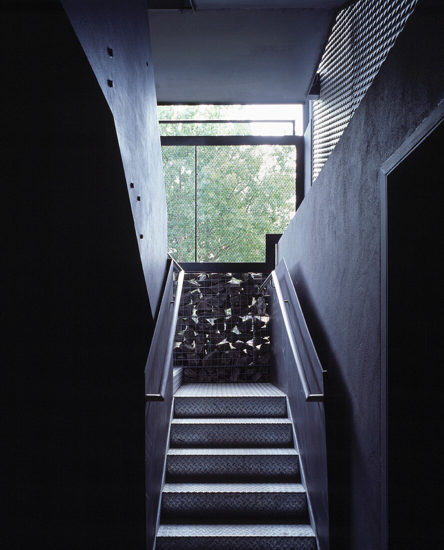 Narrow staircase with metal treads and balustrades and gabion wall