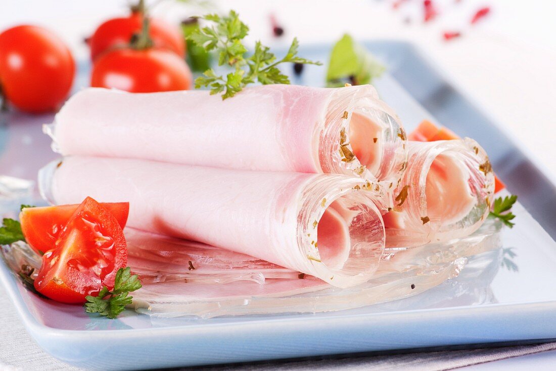 Rolls of ham in aspic with tomatoes