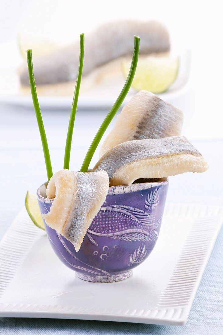 Soused herring fillets in a blue cup