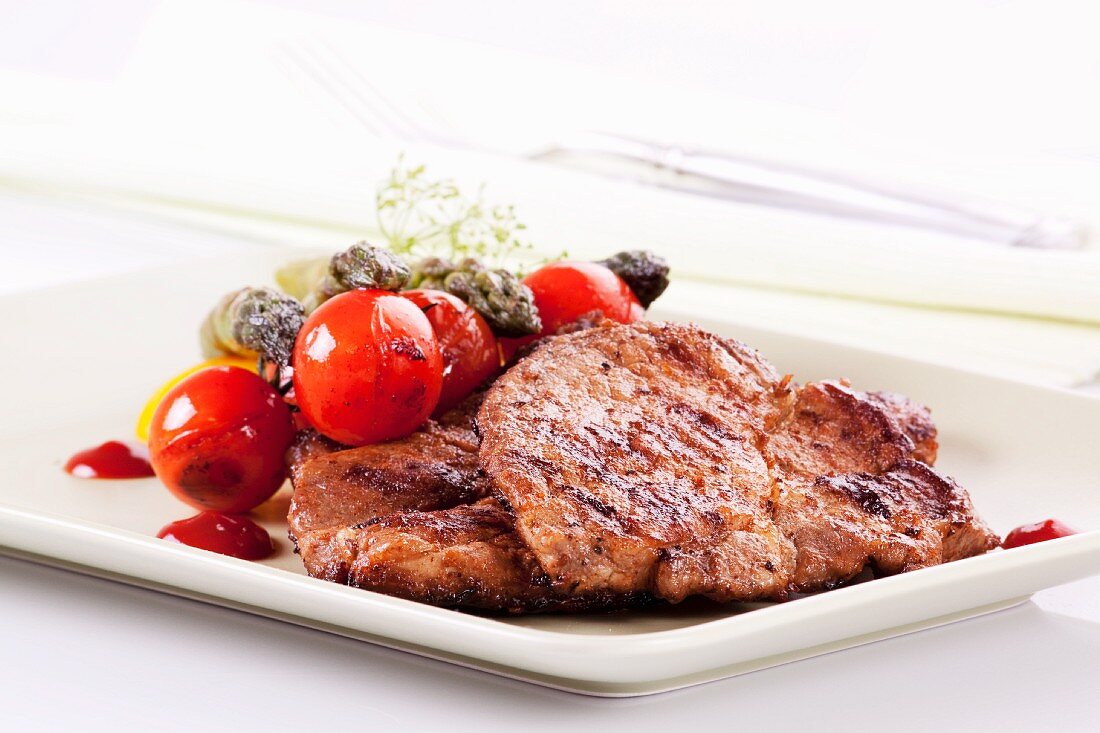 Grilled pork collar steak with a side of vegetables